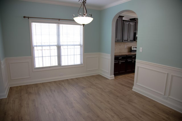 4745 Willman Way, Lexington, KY 40509 - unfurnished room featuring arched walkways, a wainscoted wall, a decorative wall, light wood-style flooring, and ornamental molding