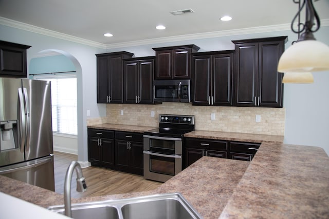 4745 Willman Way, Lexington, KY 40509 - kitchen featuring stainless steel appliances, light wood finished floors, arched walkways, decorative backsplash, and crown molding