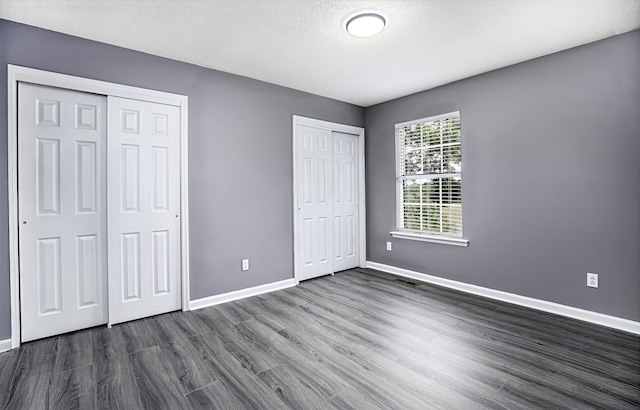 113 Bramble Ct, Nicholasville, KY 40356 - unfurnished bedroom featuring multiple closets, dark wood-type flooring, and baseboards