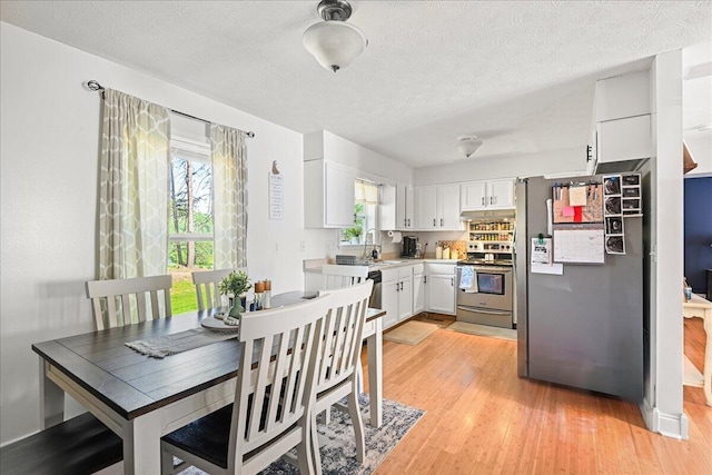 1008 Ramsey Branch Rd, Artemus, KY 40903 - dining area featuring light wood-style flooring and a textured ceiling