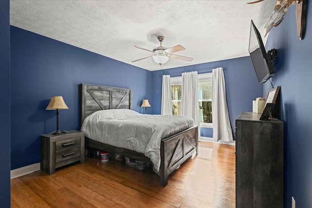 1008 Ramsey Branch Rd, Artemus, KY 40903 - bedroom featuring wood finished floors, a textured ceiling, a ceiling fan, and baseboards