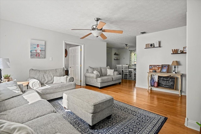 1008 Ramsey Branch Rd, Artemus, KY 40903 - living room with wood finished floors, ceiling fan, and a textured ceiling