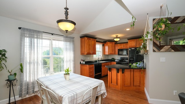754 Countryside Cir, Mount Vernon, KY 40456 - kitchen featuring black appliances, brown cabinetry, vaulted ceiling, wood finished floors, and dark countertops