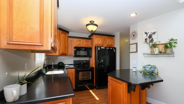754 Countryside Cir, Mount Vernon, KY 40456 - kitchen featuring black appliances, a sink, dark countertops, wood finished floors, and a breakfast bar