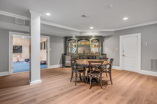 1617 Harmony Hall Ln, Lexington, KY 40502 - dining area with decorative columns, bar, ornamental molding, light wood-style flooring, and baseboards