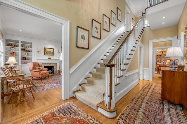 100 Idle Hour Dr Unit 8, Lexington, KY 40502 - staircase featuring ornamental molding, wood finished floors, a fireplace, a decorative wall, and a wainscoted wall