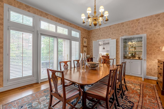 100 Idle Hour Dr Unit 8, Lexington, KY 40502 - dining room with wallpapered walls, light wood-type flooring, a chandelier, and crown molding