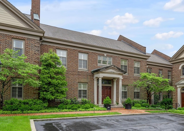 100 Idle Hour Dr Unit 8, Lexington, KY 40502 - georgian-style home featuring brick siding, roof with shingles, uncovered parking, and a chimney