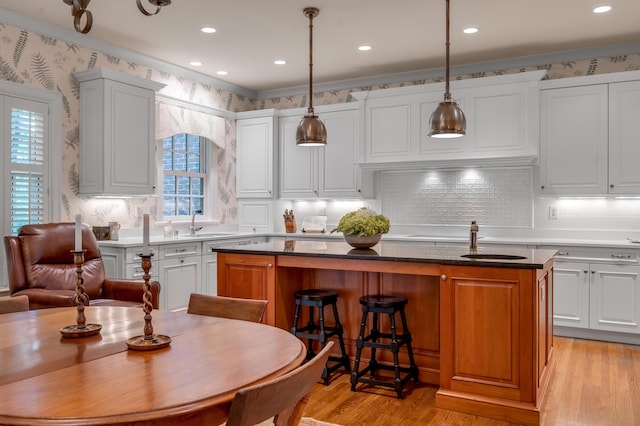 100 Idle Hour Dr Unit 8, Lexington, KY 40502 - kitchen featuring a center island, wallpapered walls, a sink, light wood-type flooring, and backsplash