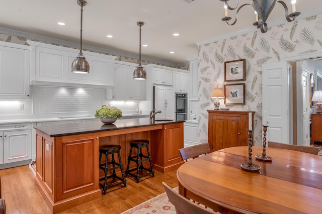100 Idle Hour Dr Unit 8, Lexington, KY 40502 - kitchen featuring light wood-style flooring, backsplash, white cabinetry, an island with sink, and ornamental molding