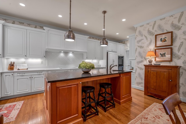 100 Idle Hour Dr Unit 8, Lexington, KY 40502 - kitchen with a sink, light wood-style flooring, a kitchen island with sink, white cabinets, and wallpapered walls