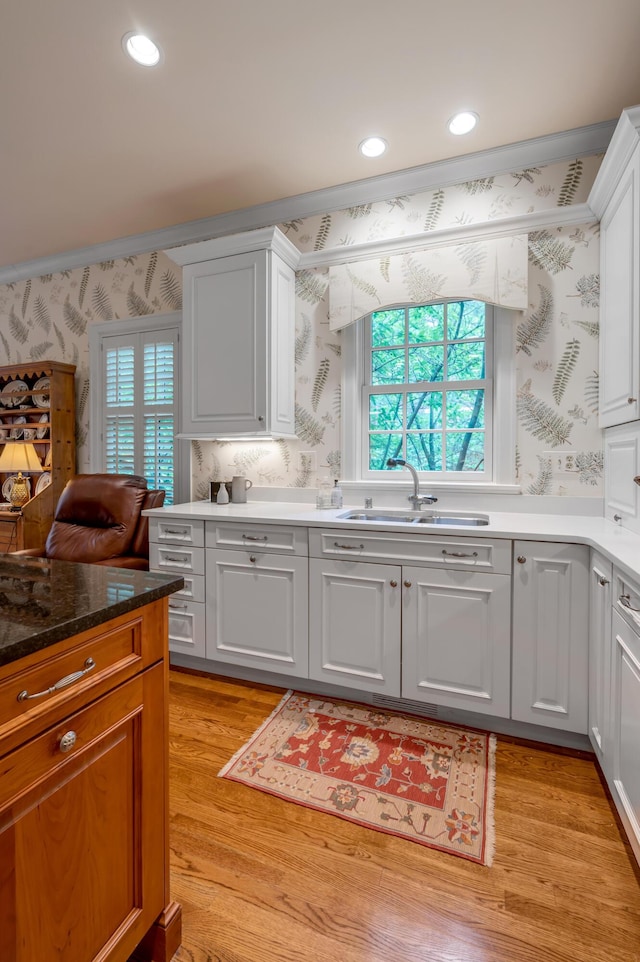 100 Idle Hour Dr Unit 8, Lexington, KY 40502 - kitchen with wallpapered walls, a sink, white cabinets, light wood-type flooring, and recessed lighting