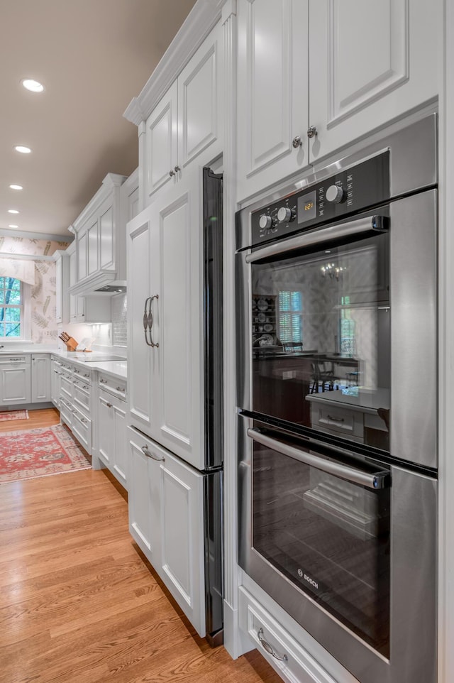 100 Idle Hour Dr Unit 8, Lexington, KY 40502 - kitchen with stainless steel double oven, paneled refrigerator, white cabinets, light wood-type flooring, and recessed lighting