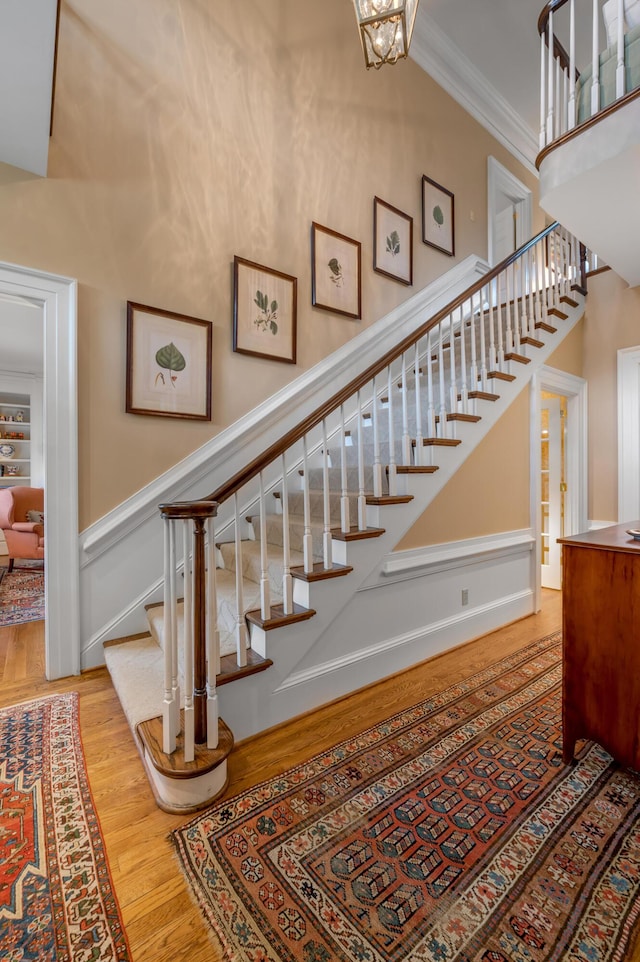 100 Idle Hour Dr Unit 8, Lexington, KY 40502 - stairway with wood finished floors, crown molding, a towering ceiling, a wainscoted wall, and a decorative wall