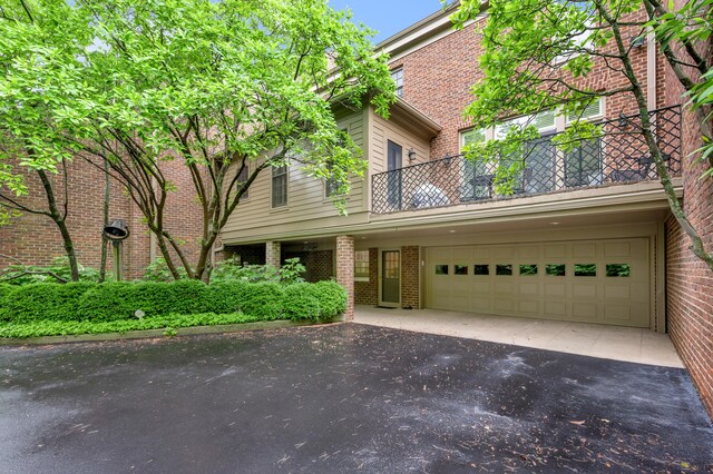 100 Idle Hour Dr Unit 8, Lexington, KY 40502 - view of front of property with asphalt driveway, a balcony, brick siding, and a garage