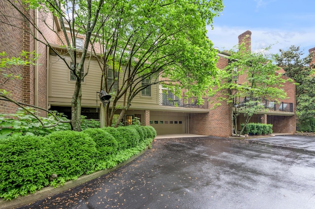 100 Idle Hour Dr Unit 8, Lexington, KY 40502 - view of front of home with driveway, brick siding, a balcony, and a garage