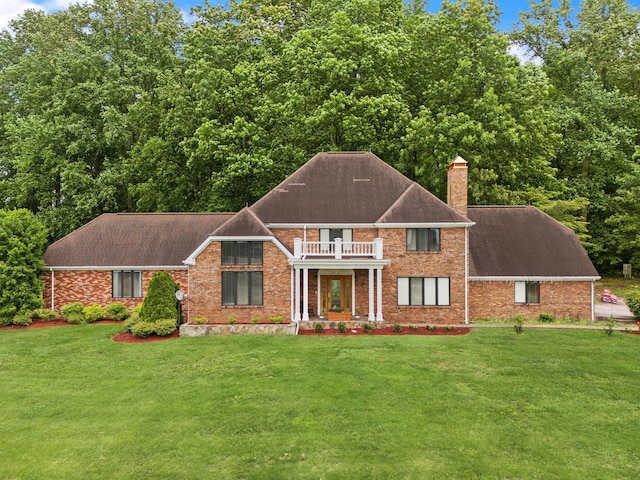 137 Indian Cave Subdivision, Monticello, KY 42633 - colonial-style house featuring a balcony, a chimney, a front yard, and brick siding