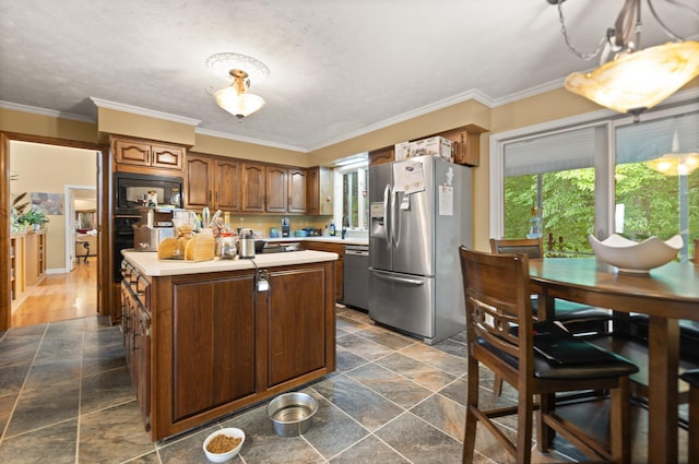 137 Indian Cave Subdivision, Monticello, KY 42633 - kitchen featuring appliances with stainless steel finishes, stone tile flooring, a kitchen island, light countertops, and ornamental molding