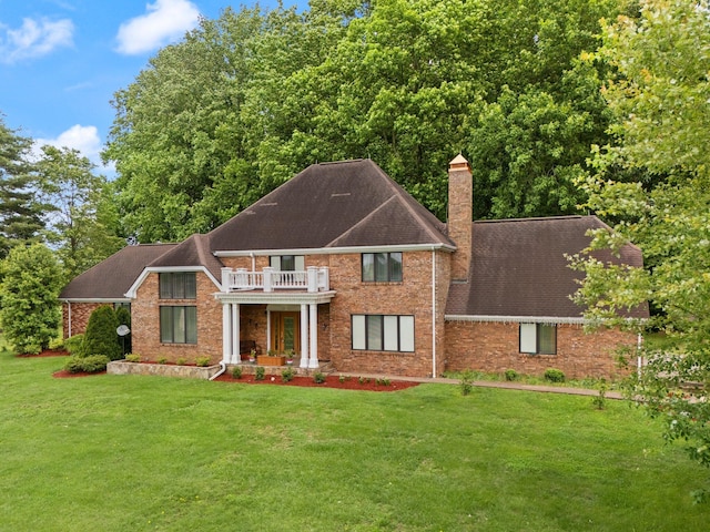 137 Indian Cave Subdivision, Monticello, KY 42633 - view of front of house with a balcony, a chimney, a front lawn, roof with shingles, and brick siding