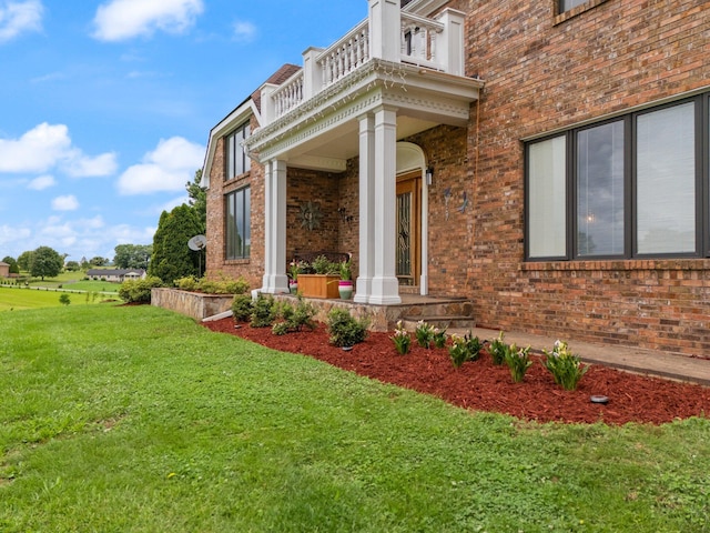 137 Indian Cave Subdivision, Monticello, KY 42633 - property entrance with a balcony, brick siding, a lawn, and a porch