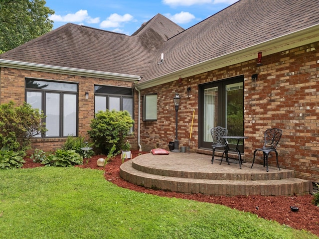 137 Indian Cave Subdivision, Monticello, KY 42633 - rear view of house featuring roof with shingles, brick siding, a lawn, and a patio