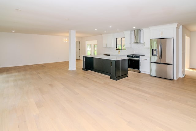 2933 Montavesta Rd, Lexington, KY 40502 - kitchen featuring appliances with stainless steel finishes, wall chimney range hood, a kitchen island, white cabinetry, and light wood-style floors