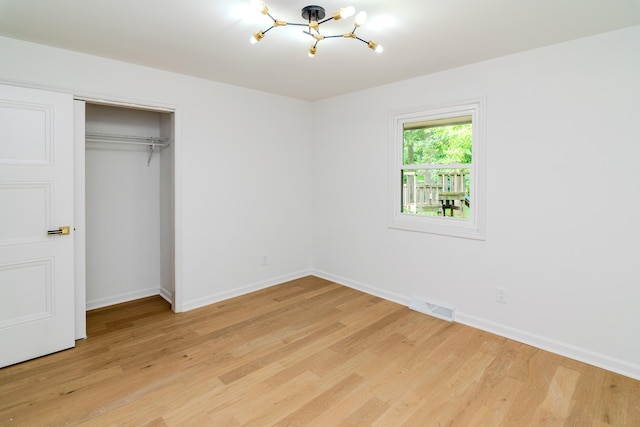2933 Montavesta Rd, Lexington, KY 40502 - unfurnished bedroom with a chandelier, light wood-type flooring, baseboards, and a closet