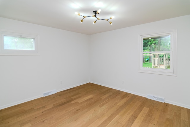 2933 Montavesta Rd, Lexington, KY 40502 - unfurnished room with a chandelier, plenty of natural light, baseboards, and light wood-style floors