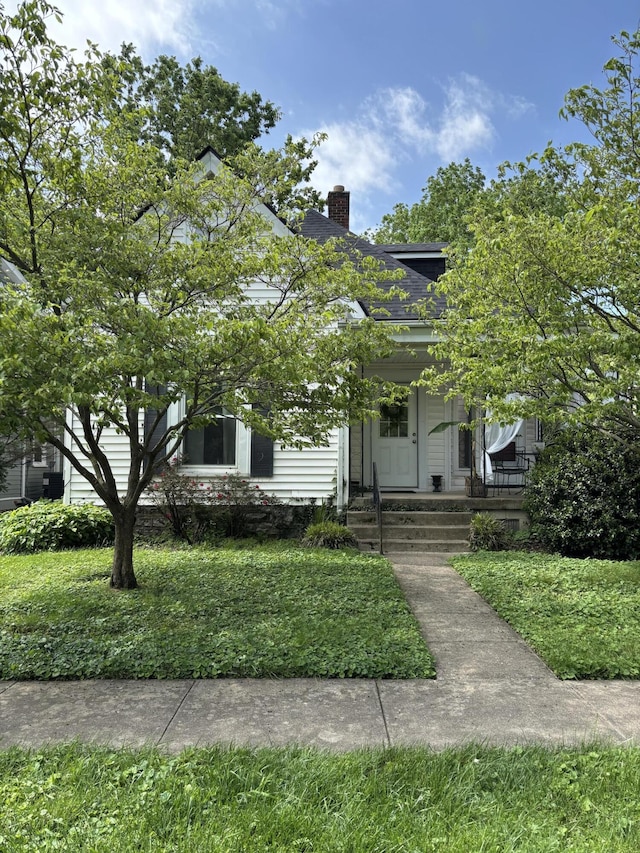 321 Clay Ave, Lexington, KY 40502 - view of property hidden behind natural elements with a porch, a chimney, a front yard, and a shingled roof