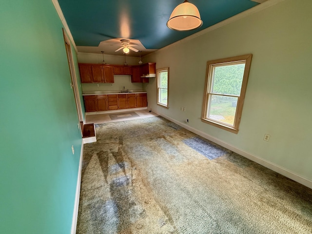 215 Bellevue Ave, Wilmore, KY 40390 - kitchen featuring ceiling fan, light carpet, brown cabinetry, ornamental molding, and light countertops