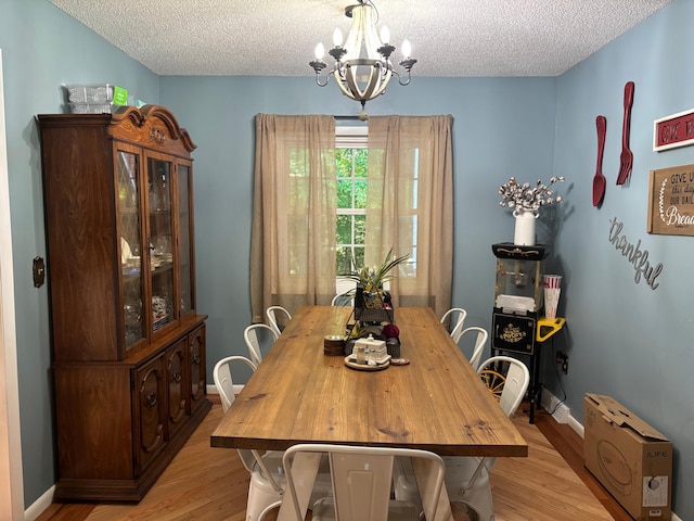 1512 Maple Ln, Corbin, KY 40701 - dining room with a textured ceiling, a chandelier, light wood-style floors, and baseboards