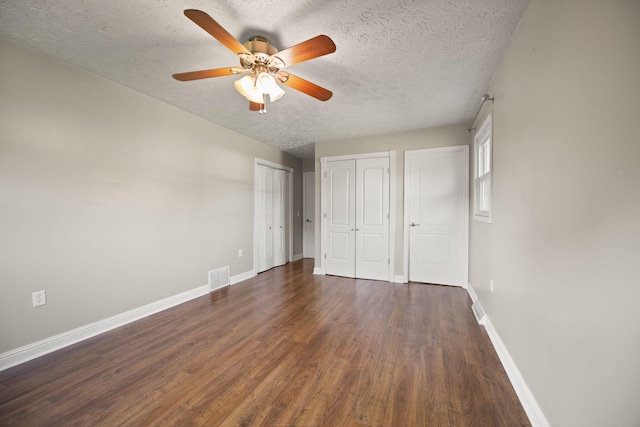 141 Springfield Dr, Corbin, KY 40701 - unfurnished bedroom featuring a textured ceiling, wood finished floors, baseboards, multiple closets, and a ceiling fan