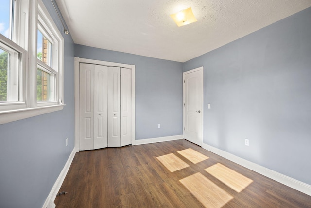 141 Springfield Dr, Corbin, KY 40701 - unfurnished bedroom with baseboards, dark wood-type flooring, and a closet