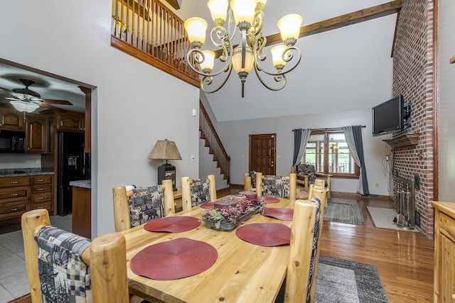 2030 Mcgee Ln, Nicholasville, KY 40356 - dining space featuring stairs, a towering ceiling, a fireplace, a chandelier, and light wood finished floors