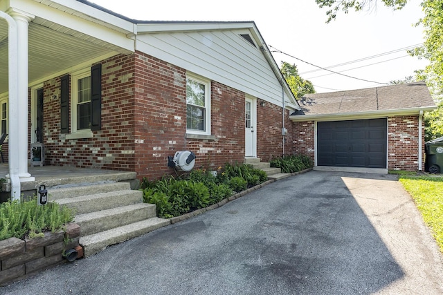 3506 Newport Dr, Lexington, KY 40517 - view of home's exterior featuring brick siding, a garage, asphalt driveway, and a porch