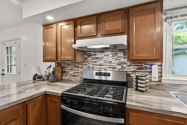 103 Cypress St, Nicholasville, KY 40356 - kitchen with stainless steel gas range, under cabinet range hood, brown cabinets, and ornamental molding