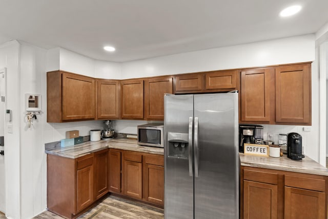 103 Cypress St, Nicholasville, KY 40356 - kitchen featuring appliances with stainless steel finishes, brown cabinets, light wood-style floors, light stone countertops, and recessed lighting