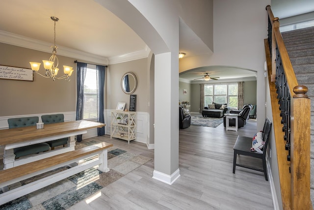 162 Johnstone Trl, Georgetown, KY 40324 - dining room featuring arched walkways, crown molding, a chandelier, a ceiling fan, and light wood-style flooring