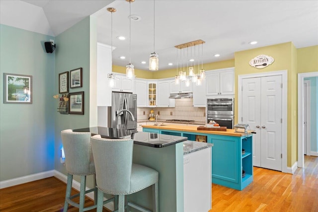 143 Winding View Trl, Georgetown, KY 40324 - kitchen featuring appliances with stainless steel finishes, a peninsula, white cabinets, decorative backsplash, and a breakfast bar