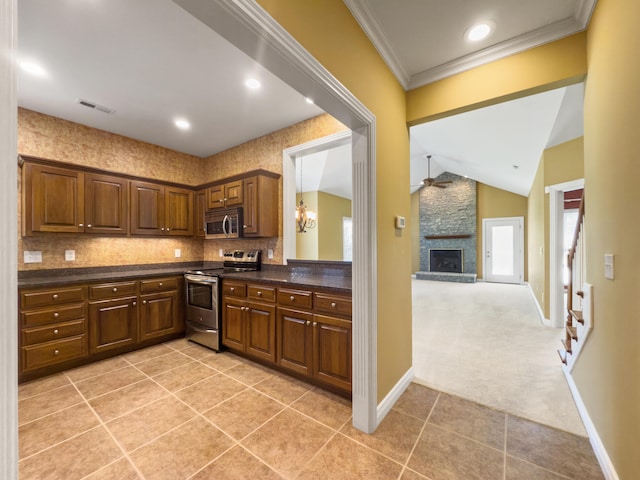2625 Flying Ebony Dr, Lexington, KY 40509 - kitchen featuring stainless steel appliances, dark countertops, a ceiling fan, light tile patterned flooring, and vaulted ceiling