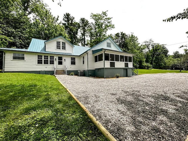 60 Furlong Ave, Burnside, KY 42519 - back of property featuring metal roof, a sunroom, gravel driveway, a yard, and view of scattered trees
