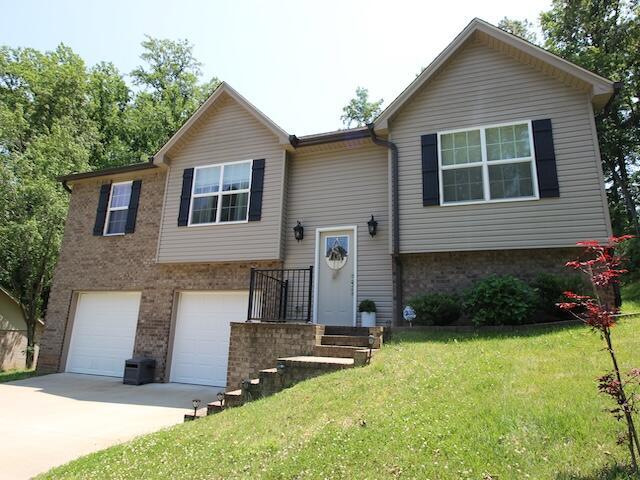 91 Graysons Way, Somerset, KY 42503 - bi-level home featuring concrete driveway, an attached garage, a front yard, and brick siding