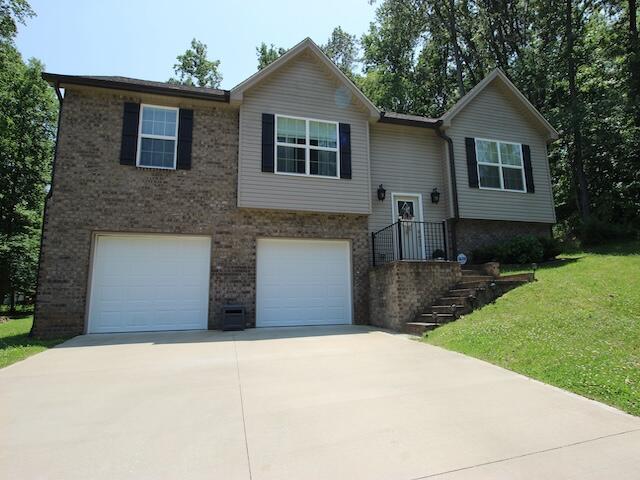 91 Graysons Way, Somerset, KY 42503 - split foyer home with an attached garage, driveway, brick siding, and a front lawn