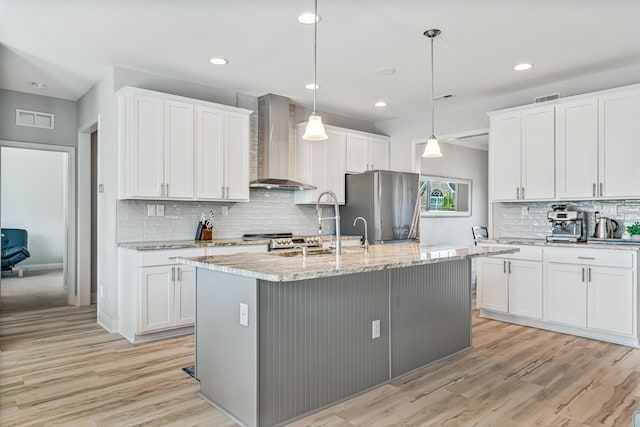 110 Kinglet Pt, Nicholasville, KY 40356 - kitchen featuring wall chimney exhaust hood, appliances with stainless steel finishes, light wood-type flooring, a kitchen island with sink, and recessed lighting