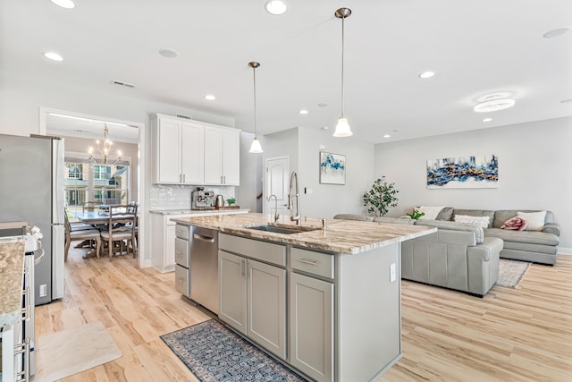 110 Kinglet Pt, Nicholasville, KY 40356 - kitchen with a sink, stainless steel appliances, light wood finished floors, a kitchen island with sink, and light stone counters