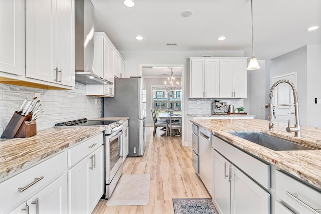 110 Kinglet Pt, Nicholasville, KY 40356 - kitchen with wall chimney range hood, appliances with stainless steel finishes, a sink, white cabinets, and light stone counters