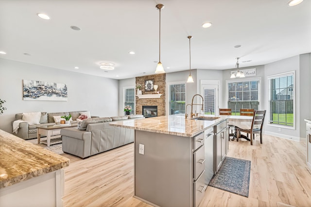 110 Kinglet Pt, Nicholasville, KY 40356 - kitchen featuring a sink, light wood-style floors, a stone fireplace, light stone counters, and recessed lighting