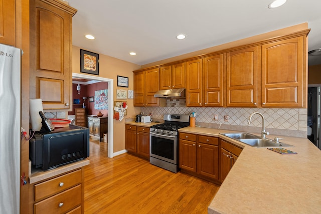 988 Fiddler Creek Way, Lexington, KY 40515 - kitchen featuring stainless steel appliances, under cabinet range hood, a sink, light wood finished floors, and light countertops