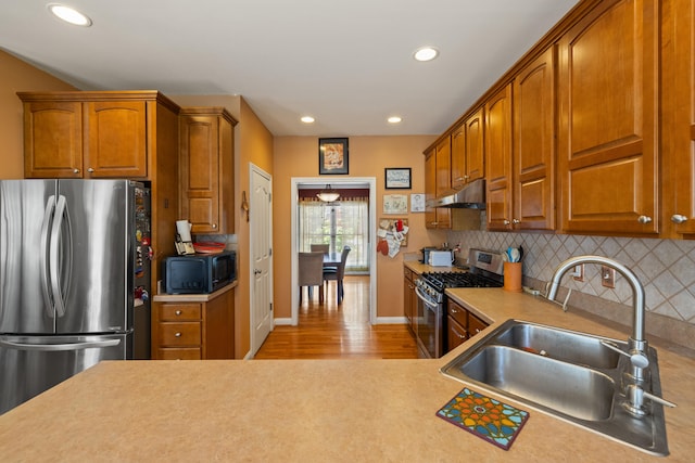 988 Fiddler Creek Way, Lexington, KY 40515 - kitchen with stainless steel appliances, a sink, under cabinet range hood, decorative backsplash, and light countertops