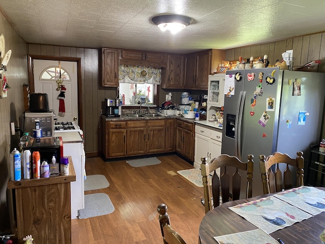 648 Hayes Creek Rd, Strunk, KY 42649 - kitchen featuring a sink, stainless steel refrigerator with ice dispenser, wood finished floors, wooden walls, and brown cabinetry